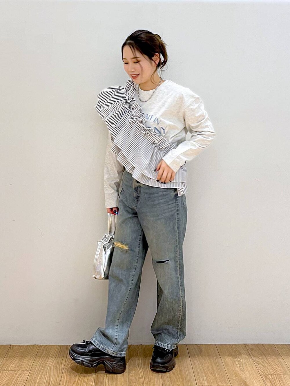 グレー系のTシャツ/カットソー、ブラック系のワンピース、ブルー系のデニムパンツを着用したレディースの春コーディネートの5枚目の写真