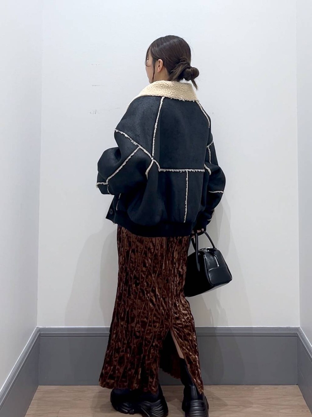 ブラック系のブーツ、ブラック系のボストンバッグ、ホワイト系のTシャツ/カットソーを着用したレディースの秋コーディネートの4枚目の写真