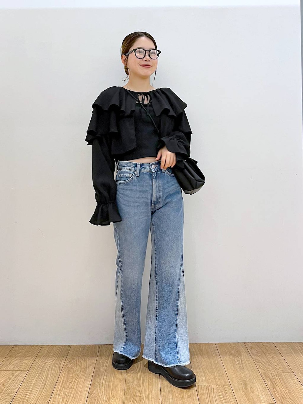 ブラック系のキャミソール、その他のデニムパンツ、ブラック系のブーツを着用したレディースの夏コーディネートの2枚目の写真