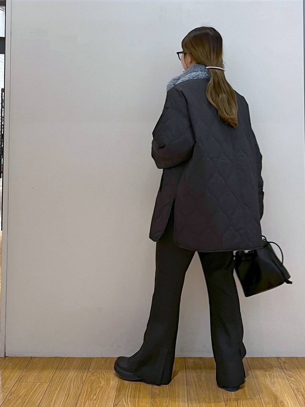 ブラック系のブルゾン、ブラック系のブーツ、ブラック系のスラックスを着用したレディースの冬コーディネートの3枚目の写真