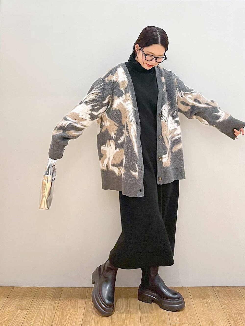 シルバー系のショルダーバッグ、ブラック系のワンピース、グレー系のカーディガン/ボレロを着用したレディースの冬コーディネートの3枚目の写真