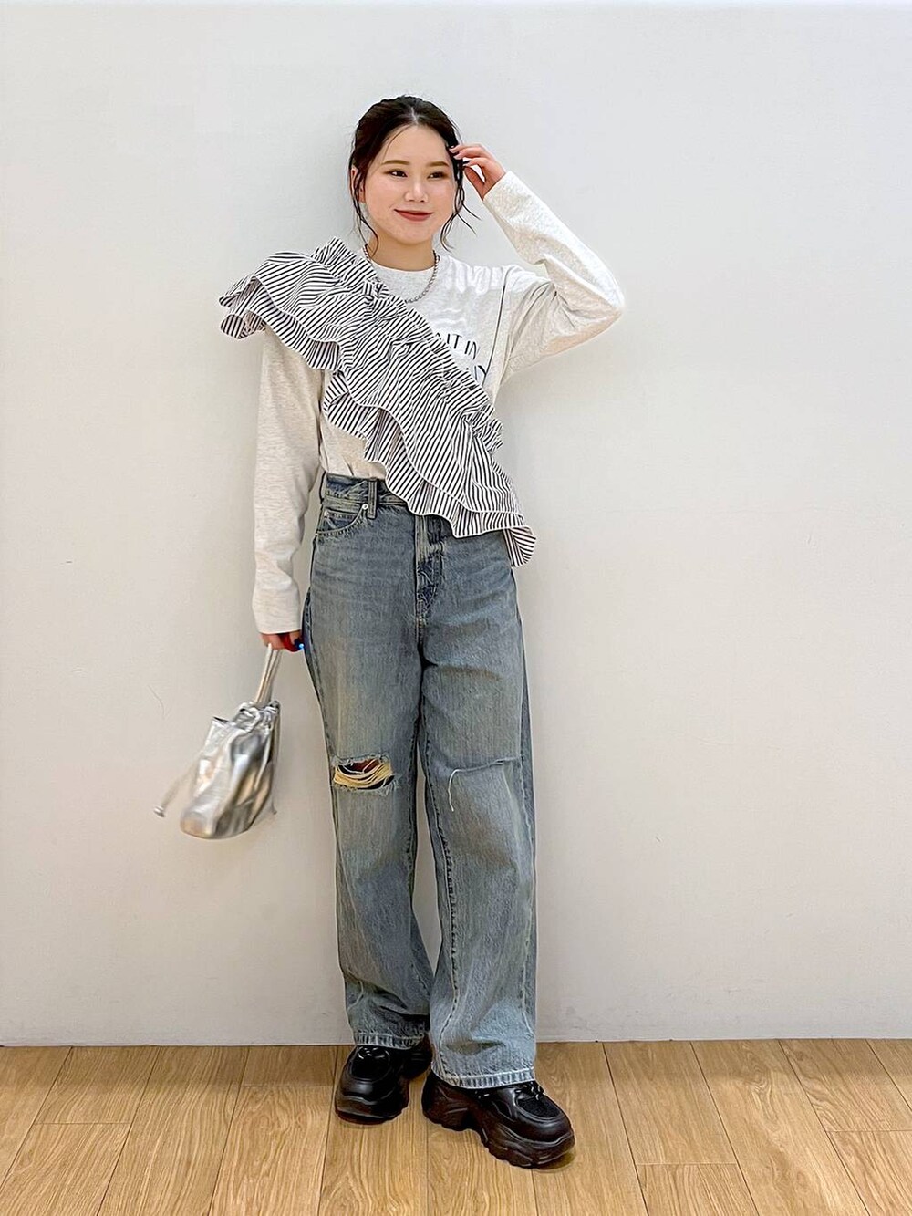グレー系のTシャツ/カットソー、ブラック系のワンピース、ブルー系のデニムパンツを着用したレディースの春コーディネートの3枚目の写真