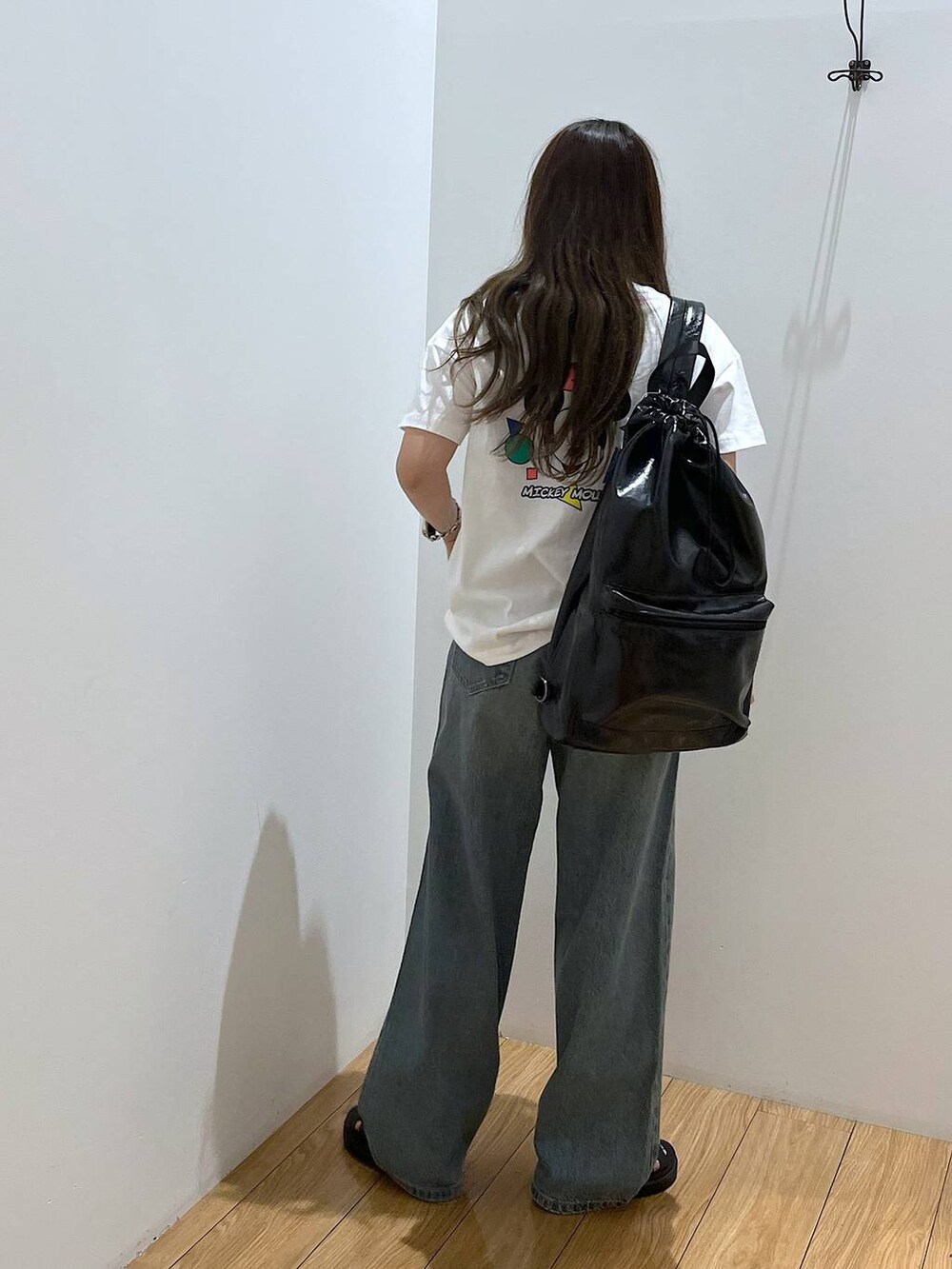 ホワイト系のTシャツ/カットソー、ブラック系のショルダーバッグ、ブラック系のスニーカーを着用したレディースの夏コーディネートの6枚目の写真