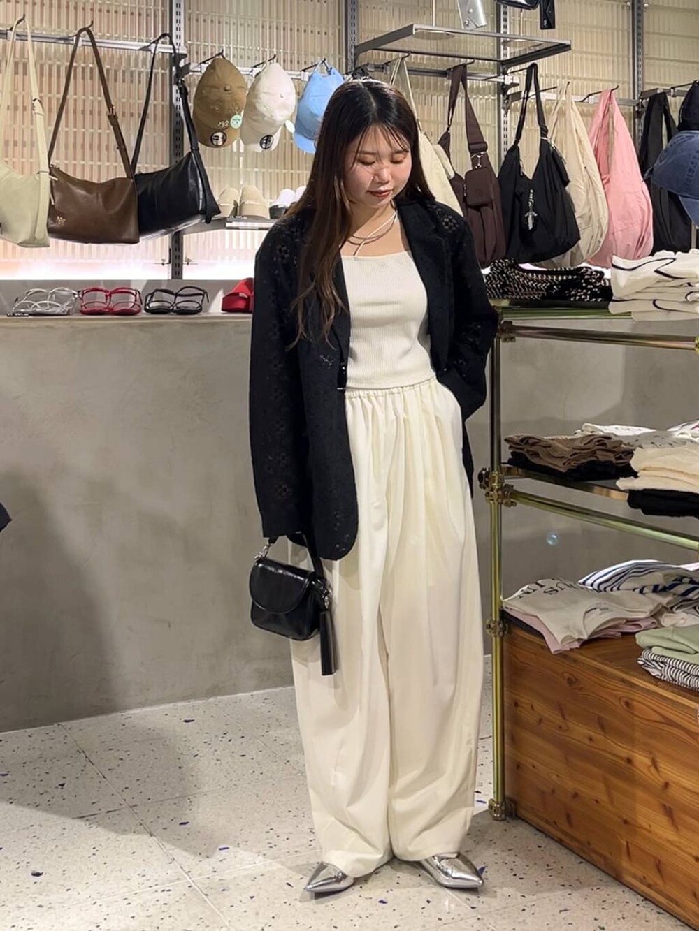 ブラック系のショルダーバッグ、シルバー系のパンプス、ベージュ系のキャミソールを着用したレディースの春コーディネートの2枚目の写真