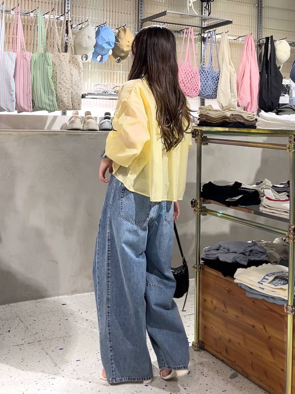 ホワイト系のキャミソール、イエロー系のシャツ/ブラウス、ブラック系のトートバッグを着用したレディースの春コーディネートの4枚目の写真