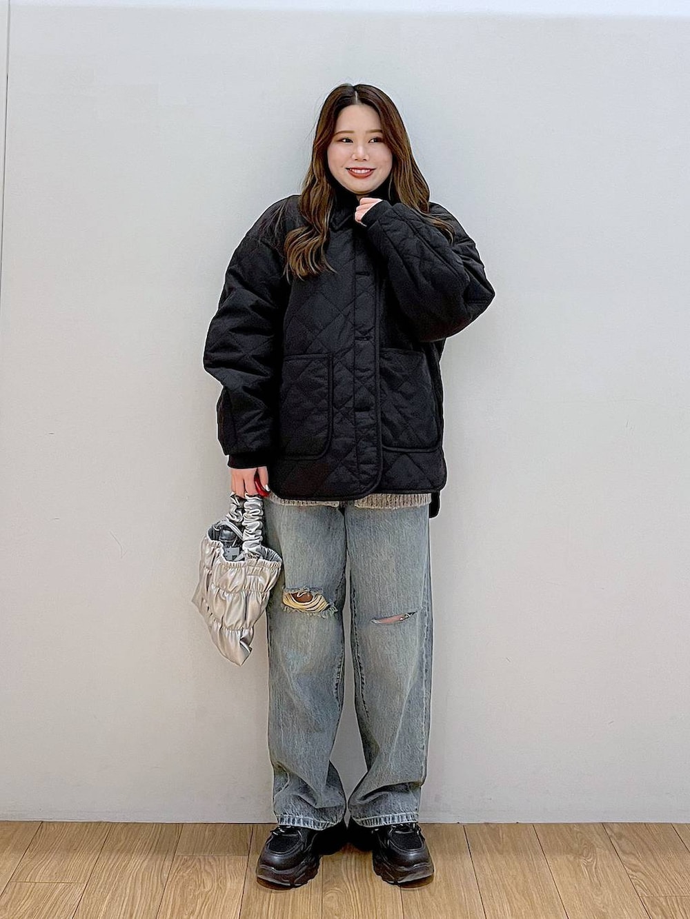 ブラック系のブルゾン、ブルー系のデニムパンツ、ブラック系のスニーカーを着用したレディースの冬コーディネートの2枚目の写真