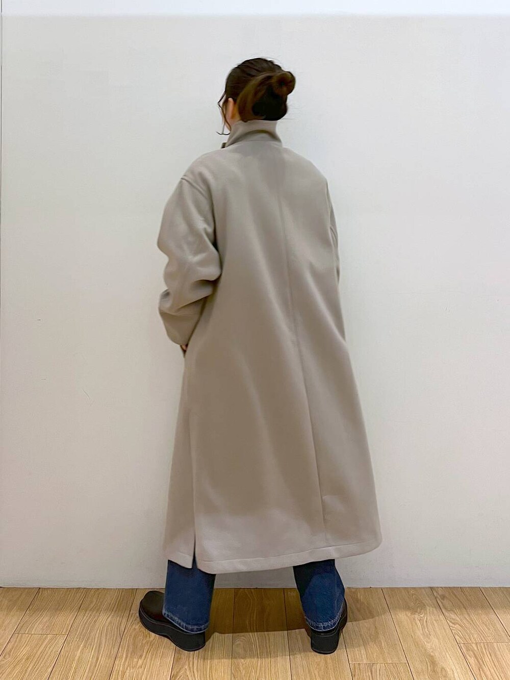 ブラウン系のチェスターコート、ブルー系のデニムパンツ、ブラック系のブーツを着用したレディースの冬コーディネートの5枚目の写真