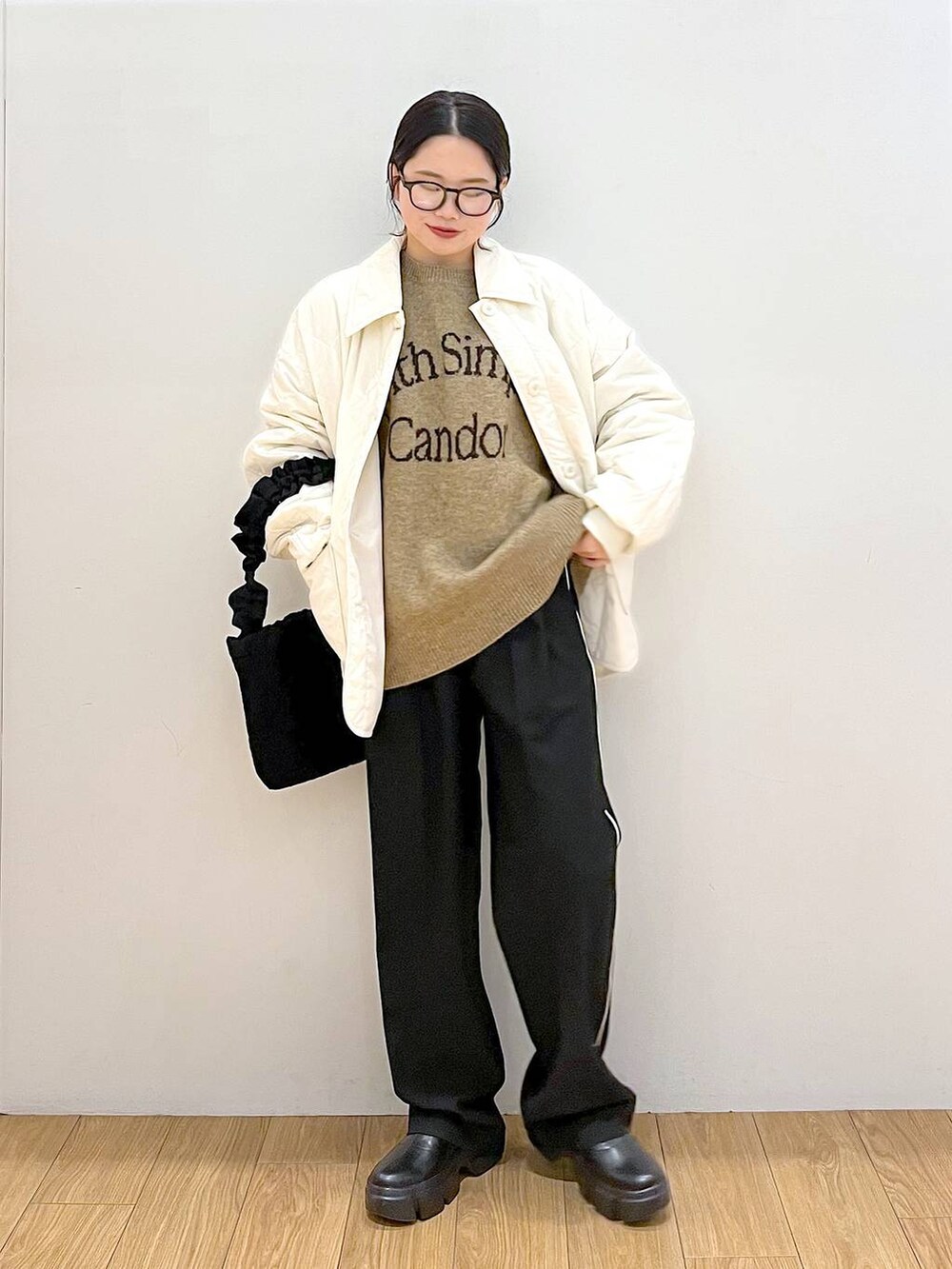 ホワイト系のニット/セーター、ブラック系のブーツ、ブラック系のその他パンツを着用したレディースの冬コーディネートの2枚目の写真