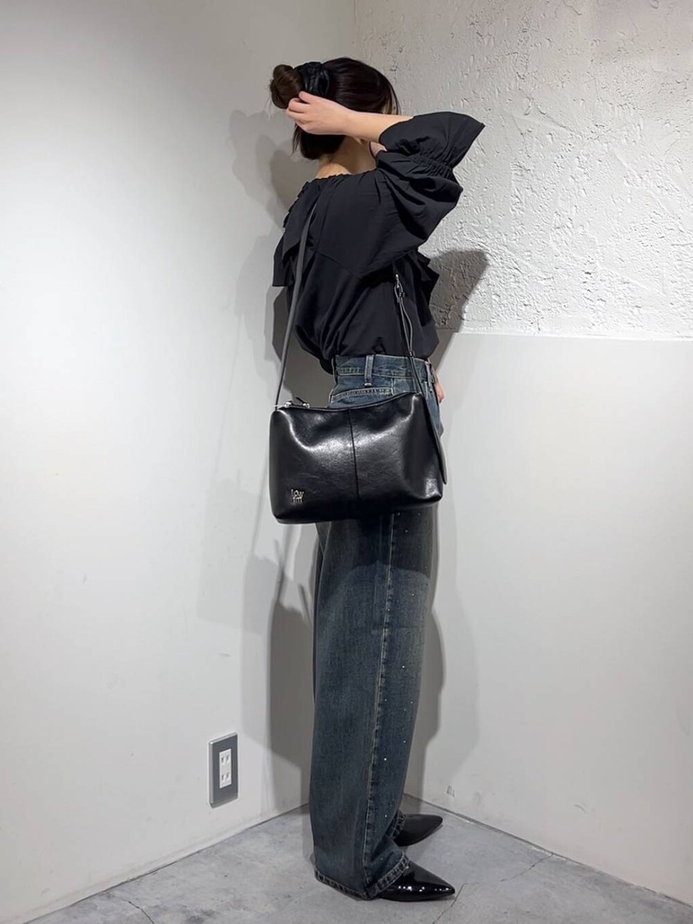 ブルー系のデニムパンツ、シルバー系のパンプス、ブラック系のシャツ/ブラウスを着用したレディースの春コーディネートの3枚目の写真