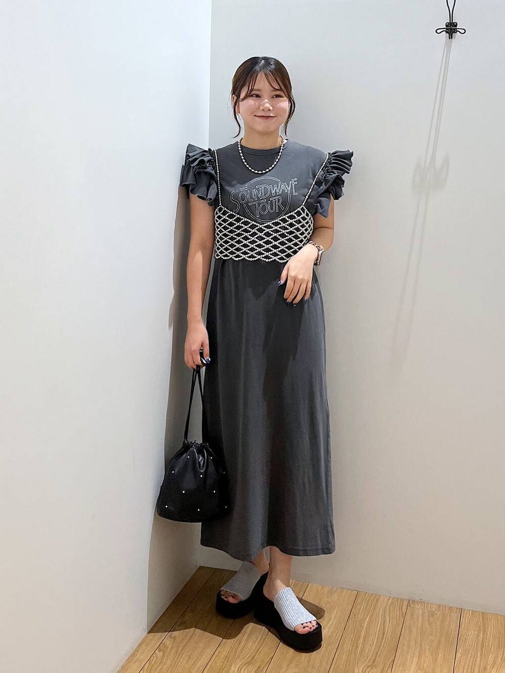 ブラック系のサンダル、ブラック系のショルダーバッグ、シルバー系のベストを着用したレディースの夏コーディネートの5枚目の写真