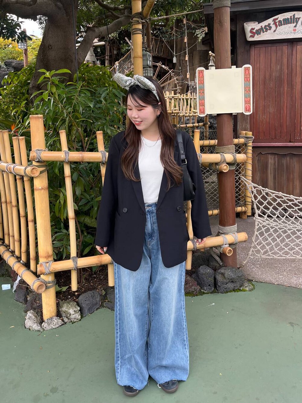 ブルー系のデニムパンツ、ブラック系のテーラードジャケット、ホワイト系のTシャツ/カットソーを着用したレディースの春コーディネートの2枚目の写真