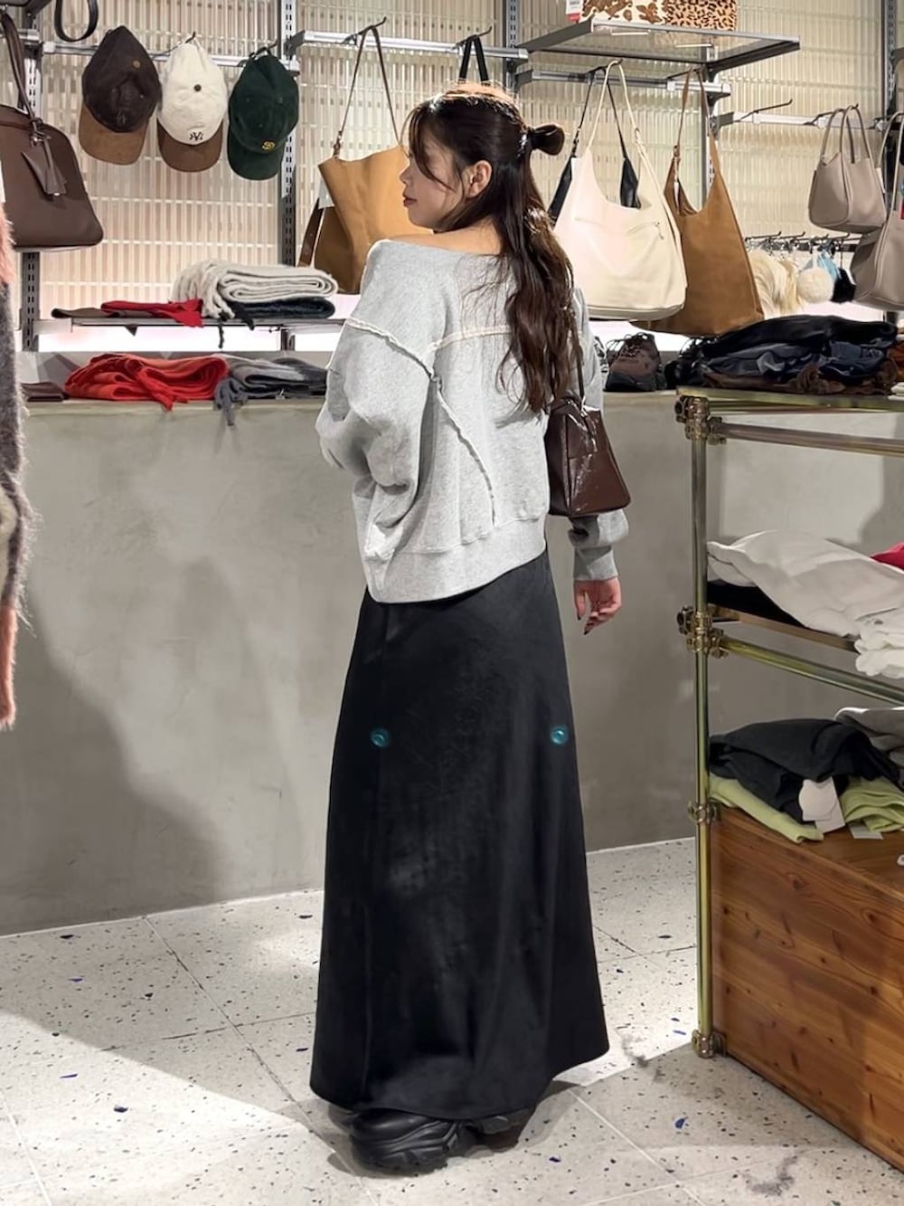 ブラック系のブーツ、グレー系のスウェット、ブラック系のスカートを着用したレディースの秋コーディネートの4枚目の写真