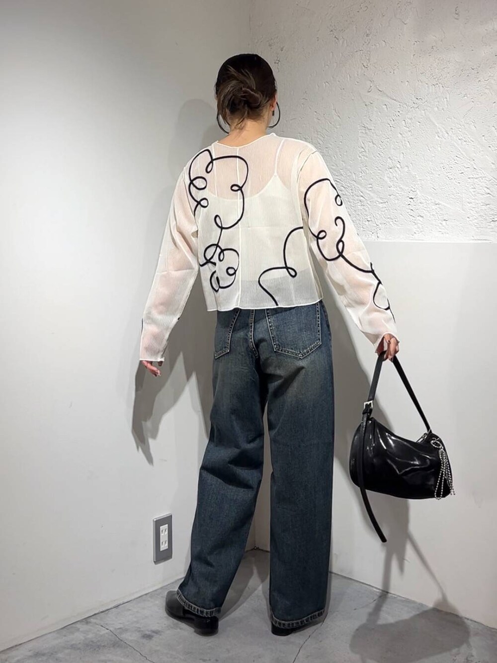 ブルー系のデニムパンツ、シルバー系のトートバッグ、シルバー系のパンプスを着用したレディースの春コーディネートの4枚目の写真