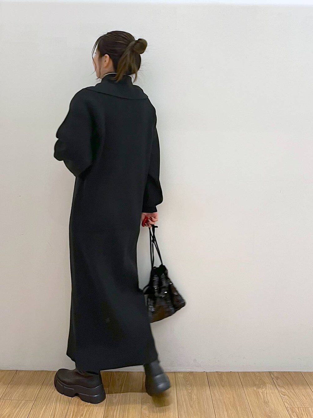 ホワイト系のTシャツ/カットソー、ブラック系のブーツ、ブラック系のハンドバッグを着用したレディースの冬コーディネートの5枚目の写真