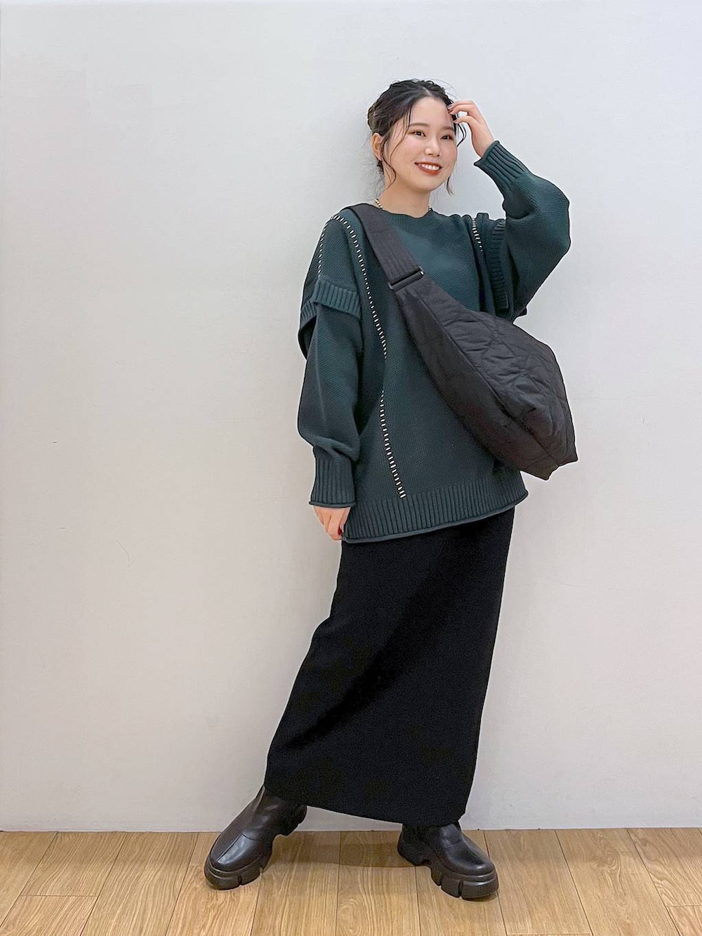 ブラック系のブーツ、ブラック系のショルダーバッグ、グリーン系のTシャツ/カットソーを着用したレディースの秋コーディネートの3枚目の写真