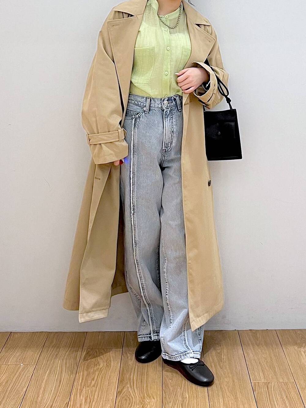ブラック系のショルダーバッグ、ブルー系のデニムパンツ、ブラック系のバレエシューズを着用したレディースの春コーディネートの4枚目の写真