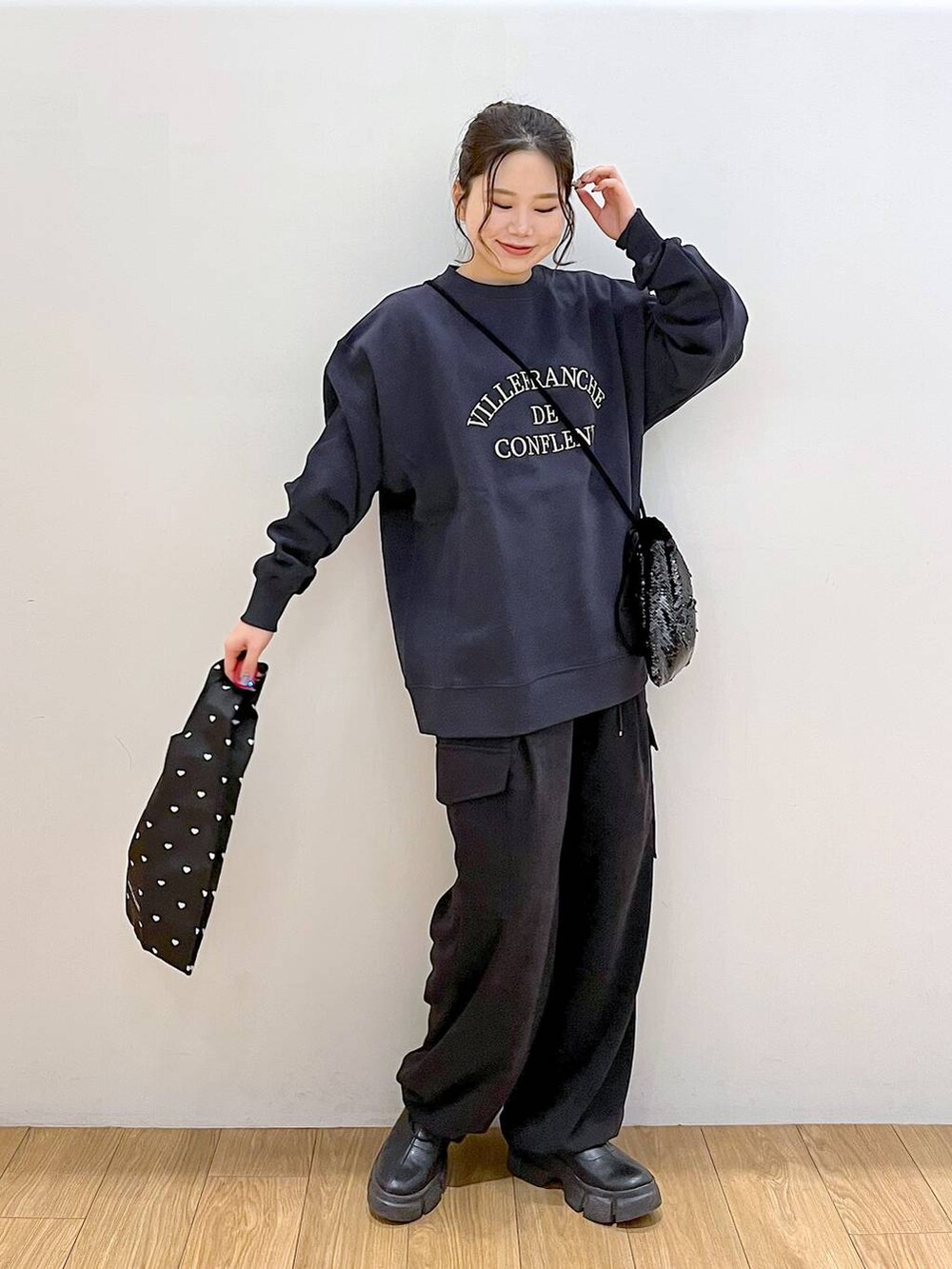 ブラック系のブーツ、ブラック系のハンドバッグ、ブラック系のカーゴパンツを着用したレディースの冬コーディネートの4枚目の写真