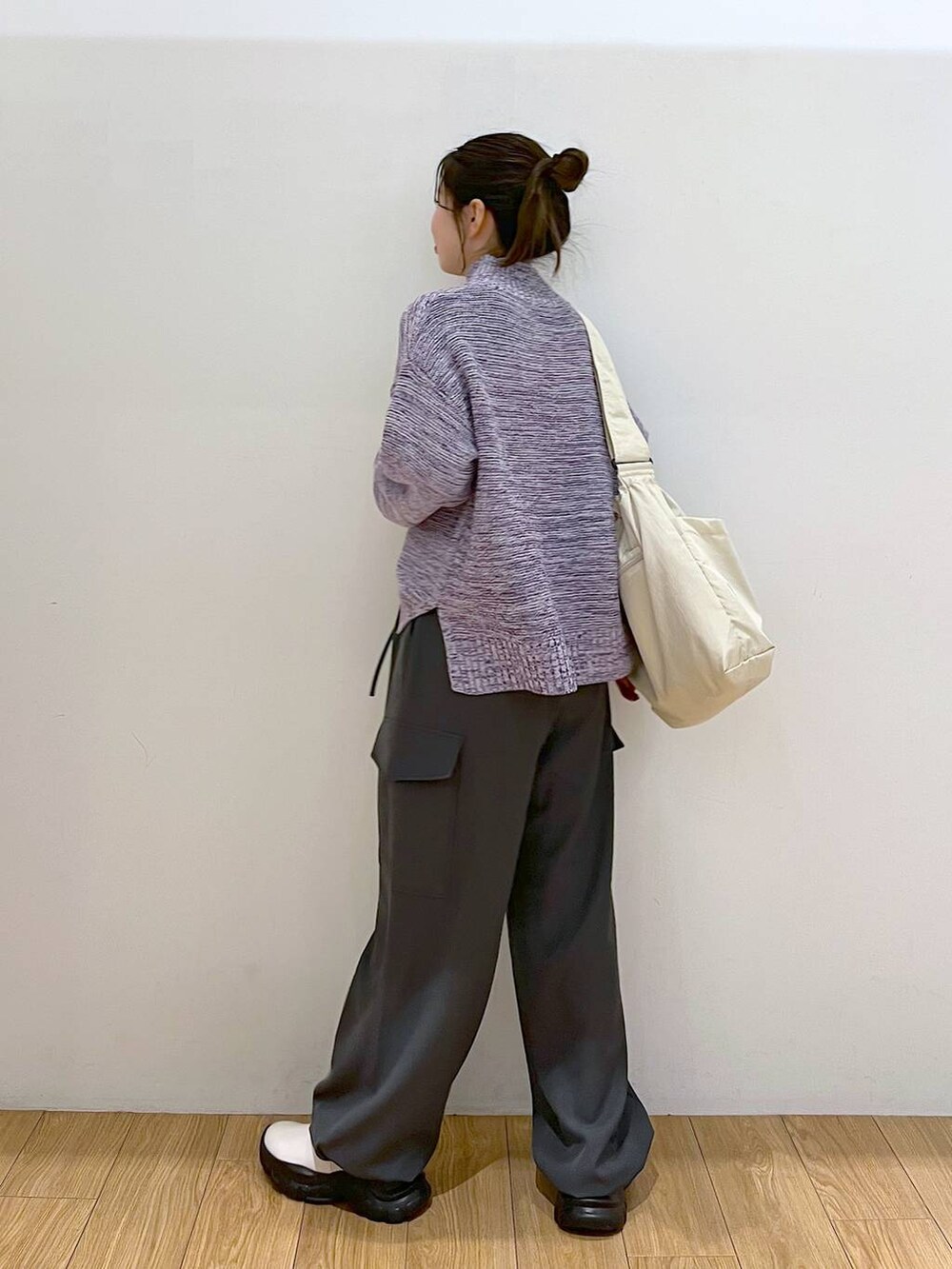 パープル系のニット/セーター、グレー系のカーゴパンツ、ホワイト系のブーツを着用したレディースの冬コーディネートの4枚目の写真
