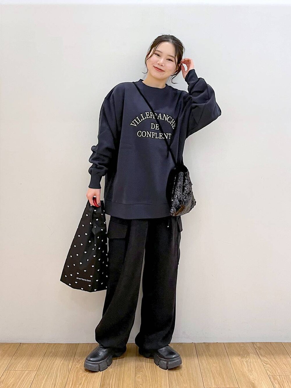 ブラック系のブーツ、ブラック系のハンドバッグ、ブラック系のカーゴパンツを着用したレディースの冬コーディネートの2枚目の写真