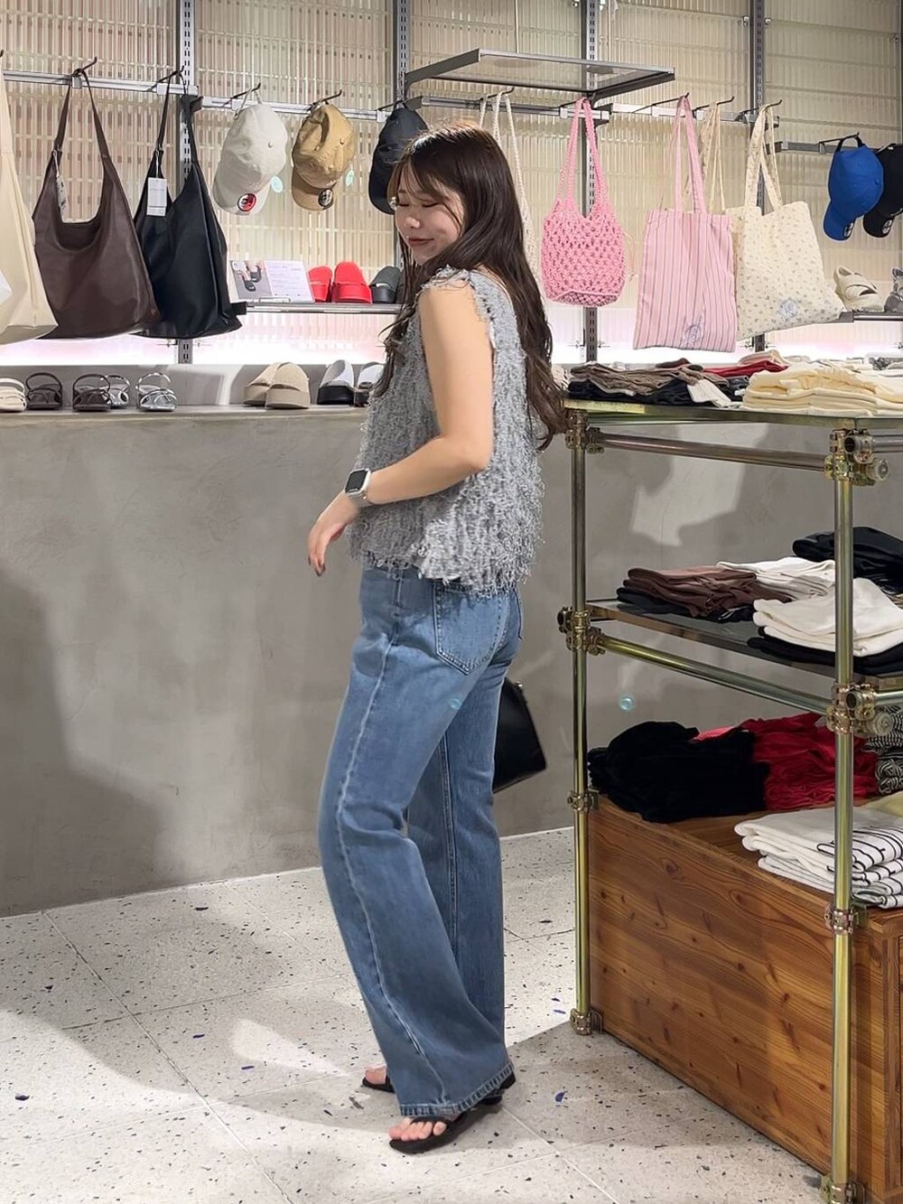 ベージュ系のキャミソール、ブラック系のサンダル、グレー系のベストを着用したレディースの春コーディネートの3枚目の写真