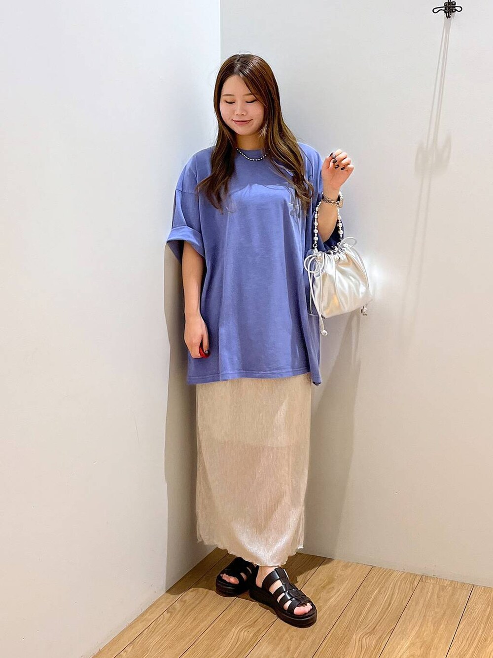 ホワイト系のスカート、ブルー系のTシャツ/カットソー、ブラック系のスニーカーを着用したレディースの夏コーディネートの2枚目の写真