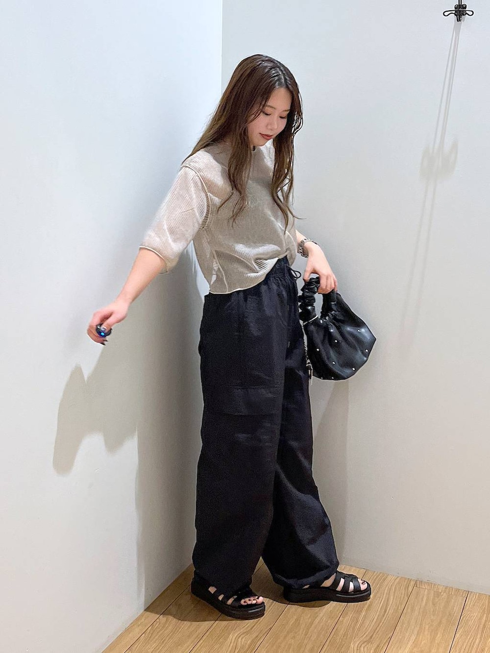 ブラック系のスニーカー、ホワイト系のTシャツ/カットソー、ブラック系のハンドバッグを着用したレディースの夏コーディネートの4枚目の写真