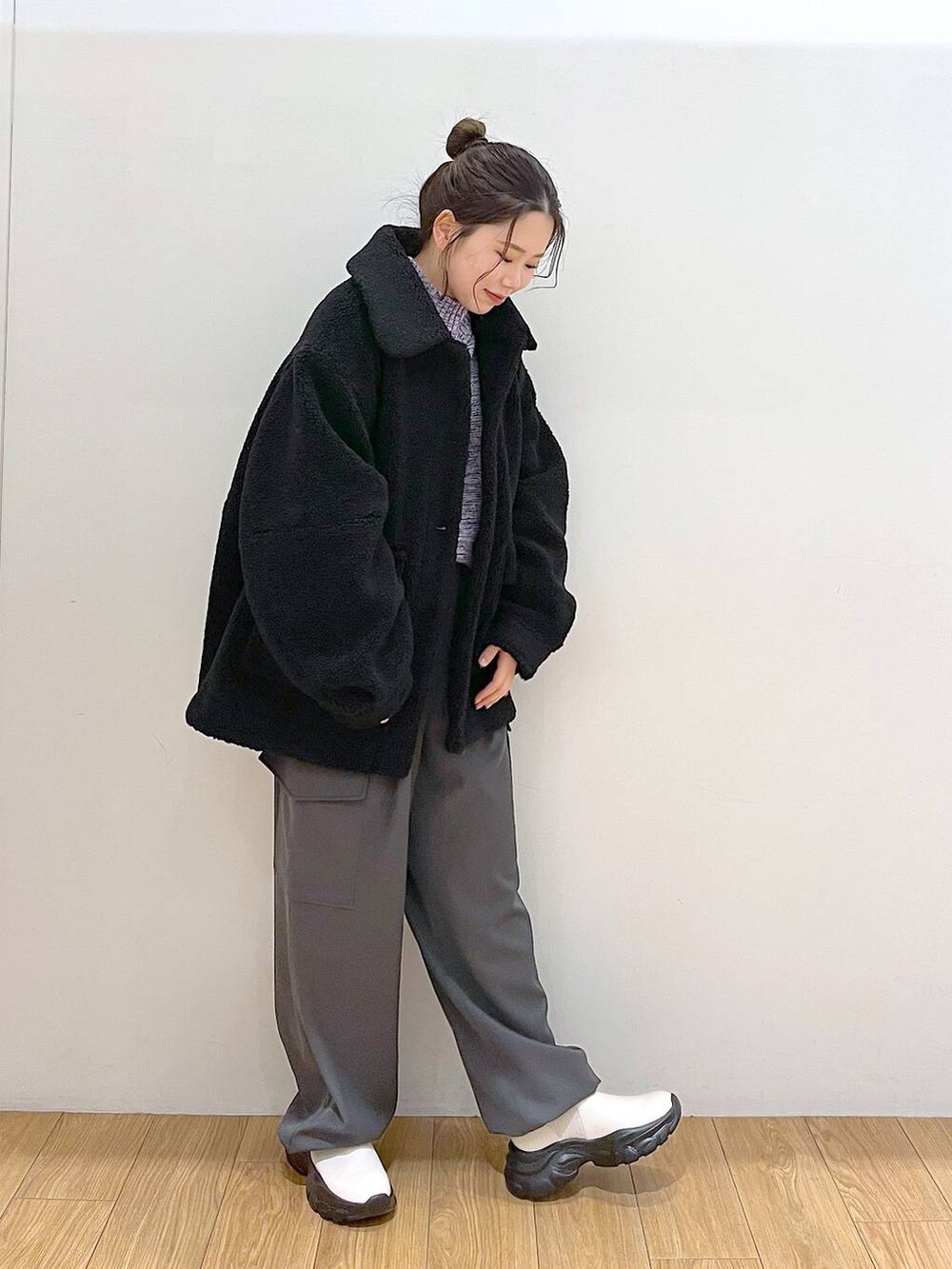 パープル系のニット/セーター、ブラック系のブルゾン、ホワイト系のブーツを着用したレディースの冬コーディネートの4枚目の写真