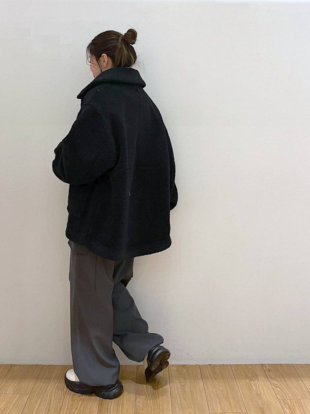 パープル系のニット/セーター、ブラック系のブルゾン、ホワイト系のブーツを着用したレディースの冬コーディネートの6枚目の写真