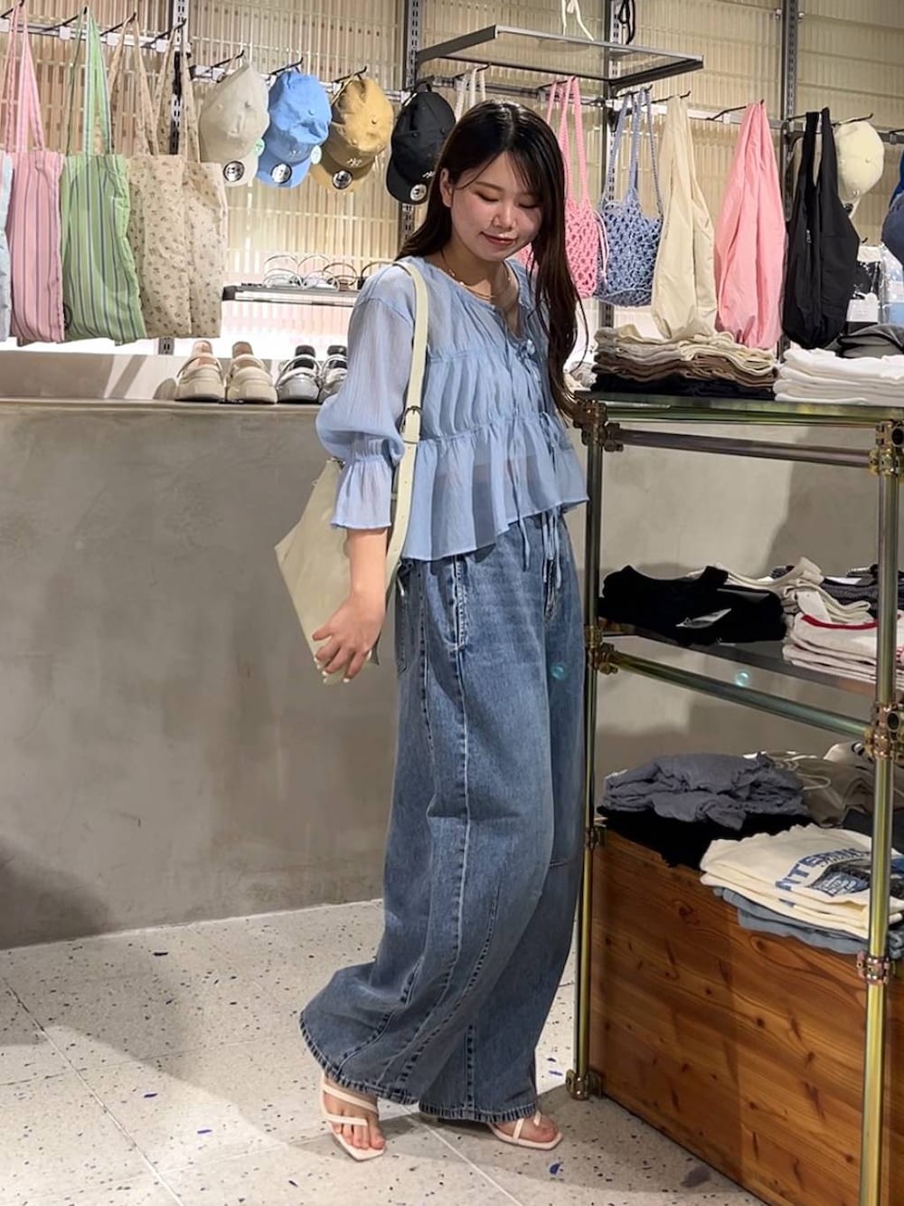 ベージュ系のキャミソール、ブルー系のシャツ/ブラウス、ブルー系のデニムパンツを着用したレディースの春コーディネートの3枚目の写真