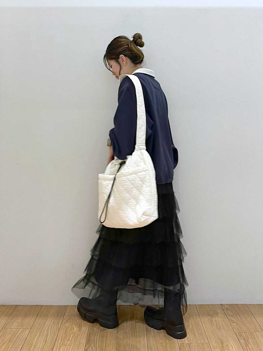 ブラック系のブーツ、ブルー系のスウェット、ブラック系のスカートを着用したレディースの秋コーディネートの7枚目の写真