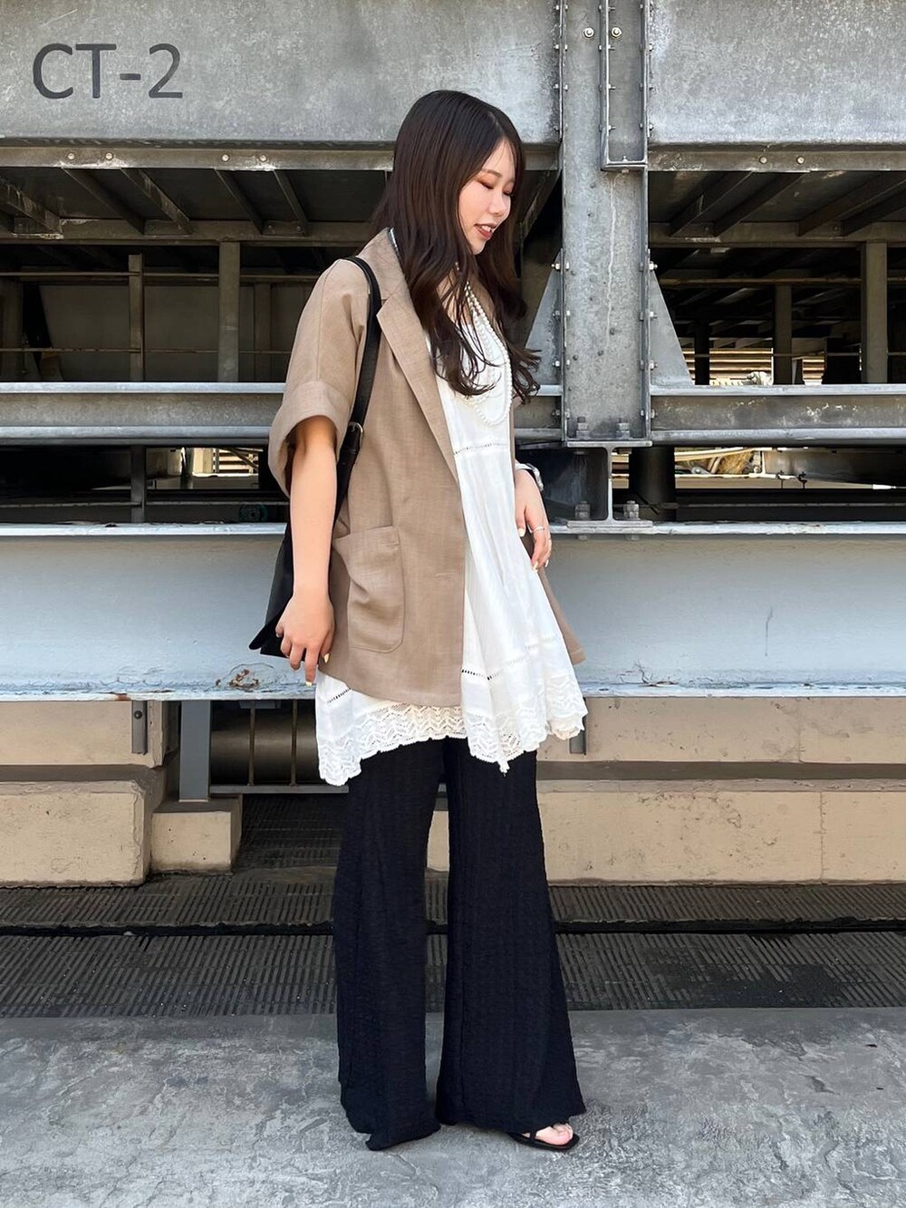 ベージュ系のショルダーバッグ、シルバー系のサンダル、ホワイト系のワンピースを着用したレディースの春コーディネートの2枚目の写真