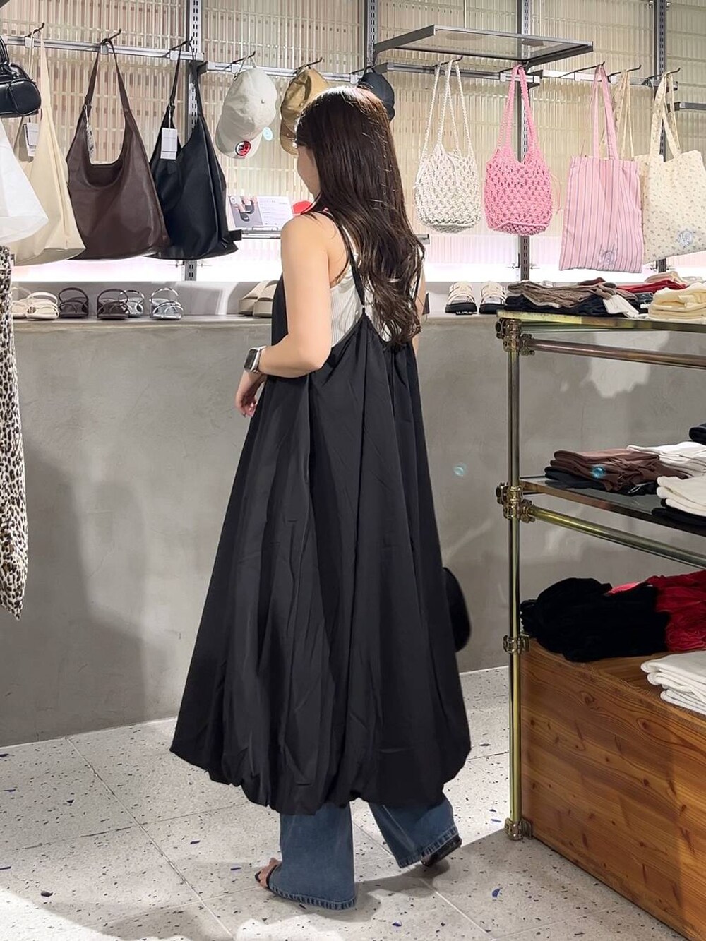 ベージュ系のキャミソール、ブラック系のワンピース、ブラック系のショルダーバッグを着用したレディースの夏コーディネートの4枚目の写真