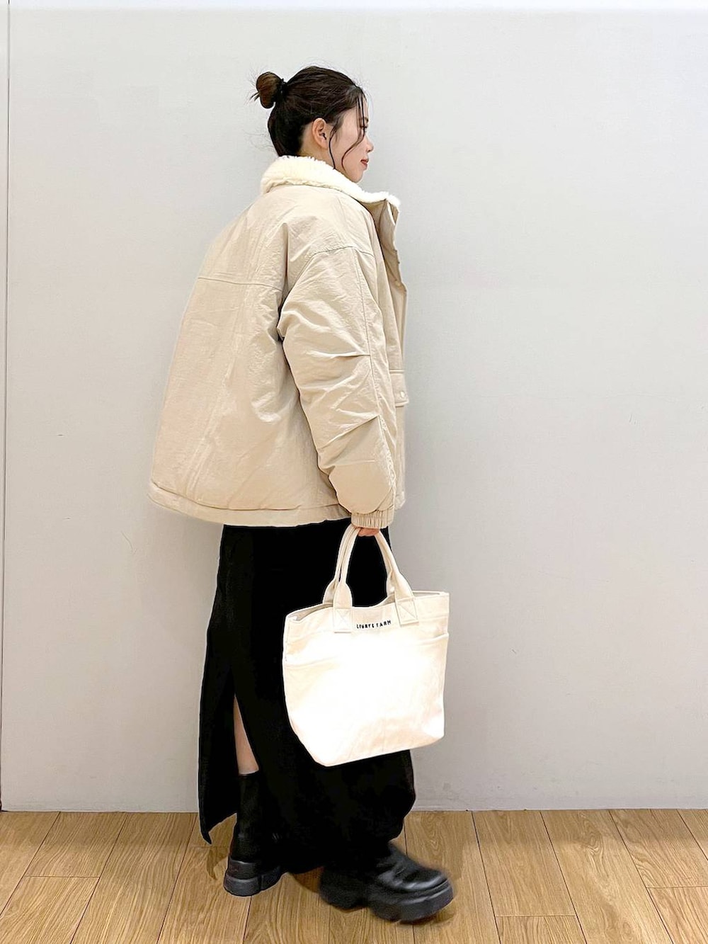 ブルー系のスウェット、ホワイト系のトートバッグ、ブラック系のブーツを着用したレディースの冬コーディネートの5枚目の写真