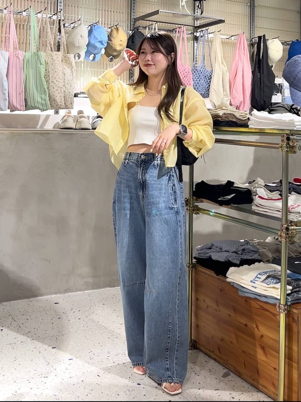 ホワイト系のキャミソール、イエロー系のシャツ/ブラウス、ブラック系のトートバッグを着用したレディースの春コーディネートの2枚目の写真