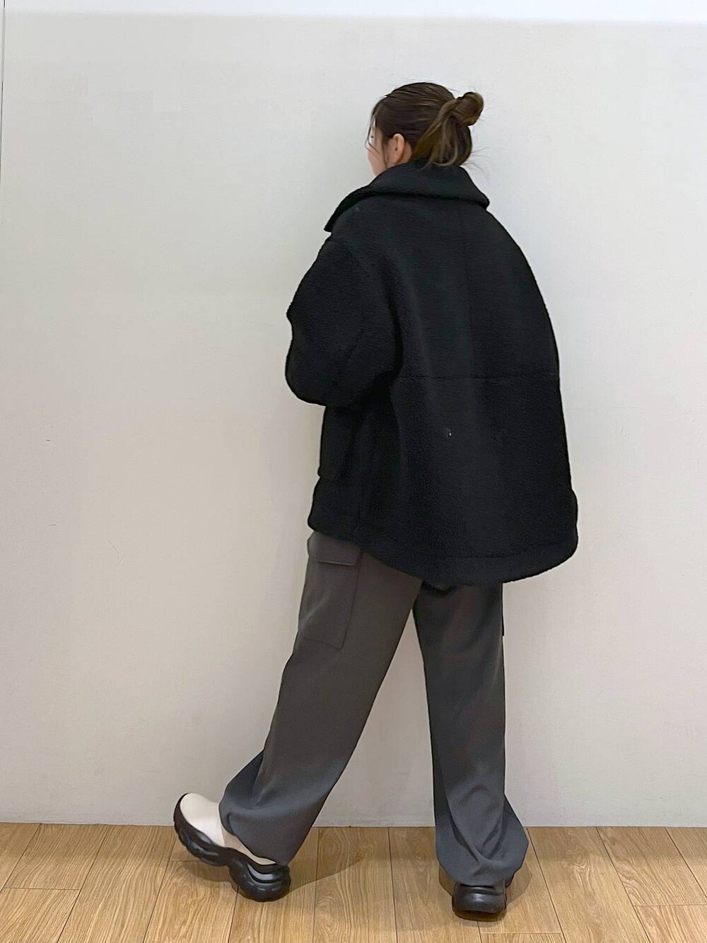 パープル系のニット/セーター、ブラック系のブルゾン、ホワイト系のブーツを着用したレディースの冬コーディネートの5枚目の写真