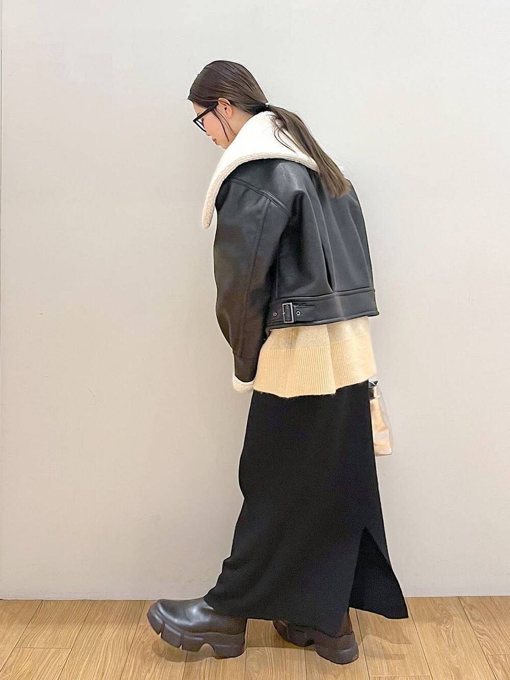 シルバー系のショルダーバッグ、ブラック系のブルゾン、ブラック系のスカートを着用したレディースの冬コーディネートの4枚目の写真