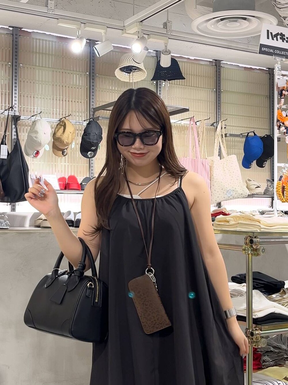 ベージュ系のキャミソール、ブラック系のワンピース、ブラック系のショルダーバッグを着用したレディースの夏コーディネートの5枚目の写真