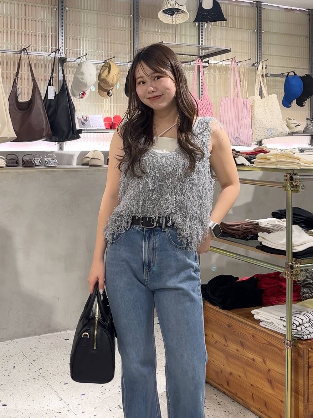 ベージュ系のキャミソール、ブラック系のサンダル、グレー系のベストを着用したレディースの春コーディネートの2枚目の写真