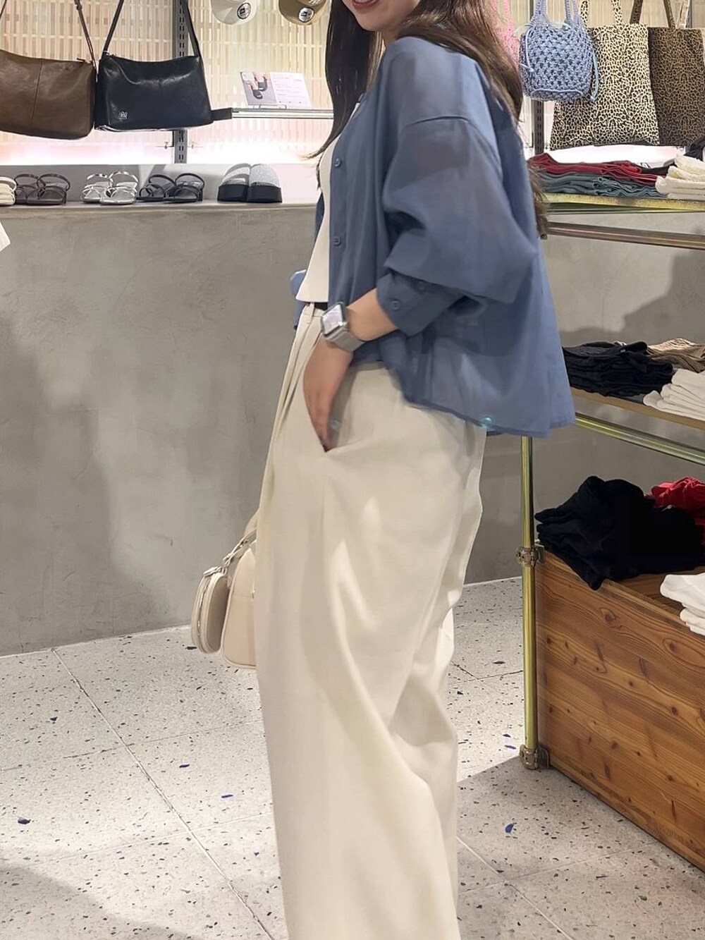 ブルー系のシャツ/ブラウス、ホワイト系のスラックス、ホワイト系のサンダルを着用したレディースの夏コーディネートの2枚目の写真