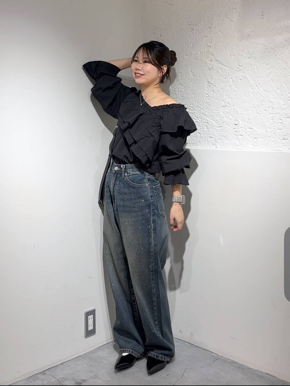 ブルー系のデニムパンツ、シルバー系のパンプス、ブラック系のシャツ/ブラウスを着用したレディースの春コーディネートの2枚目の写真