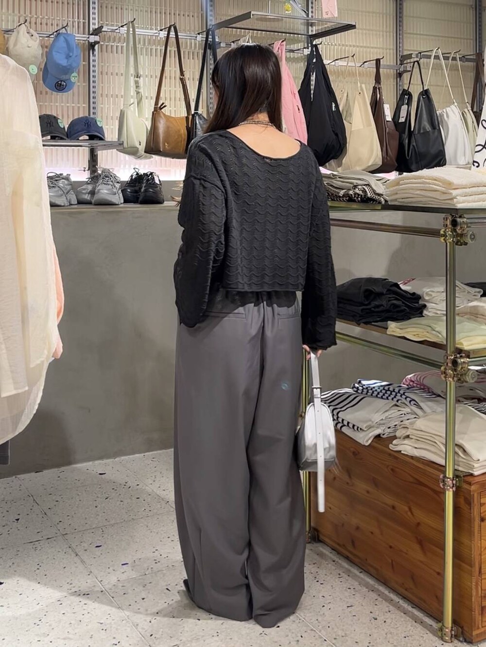 シルバー系のトートバッグ、シルバー系のパンプス、ブラック系のニット/セーターを着用したレディースの春コーディネートの3枚目の写真