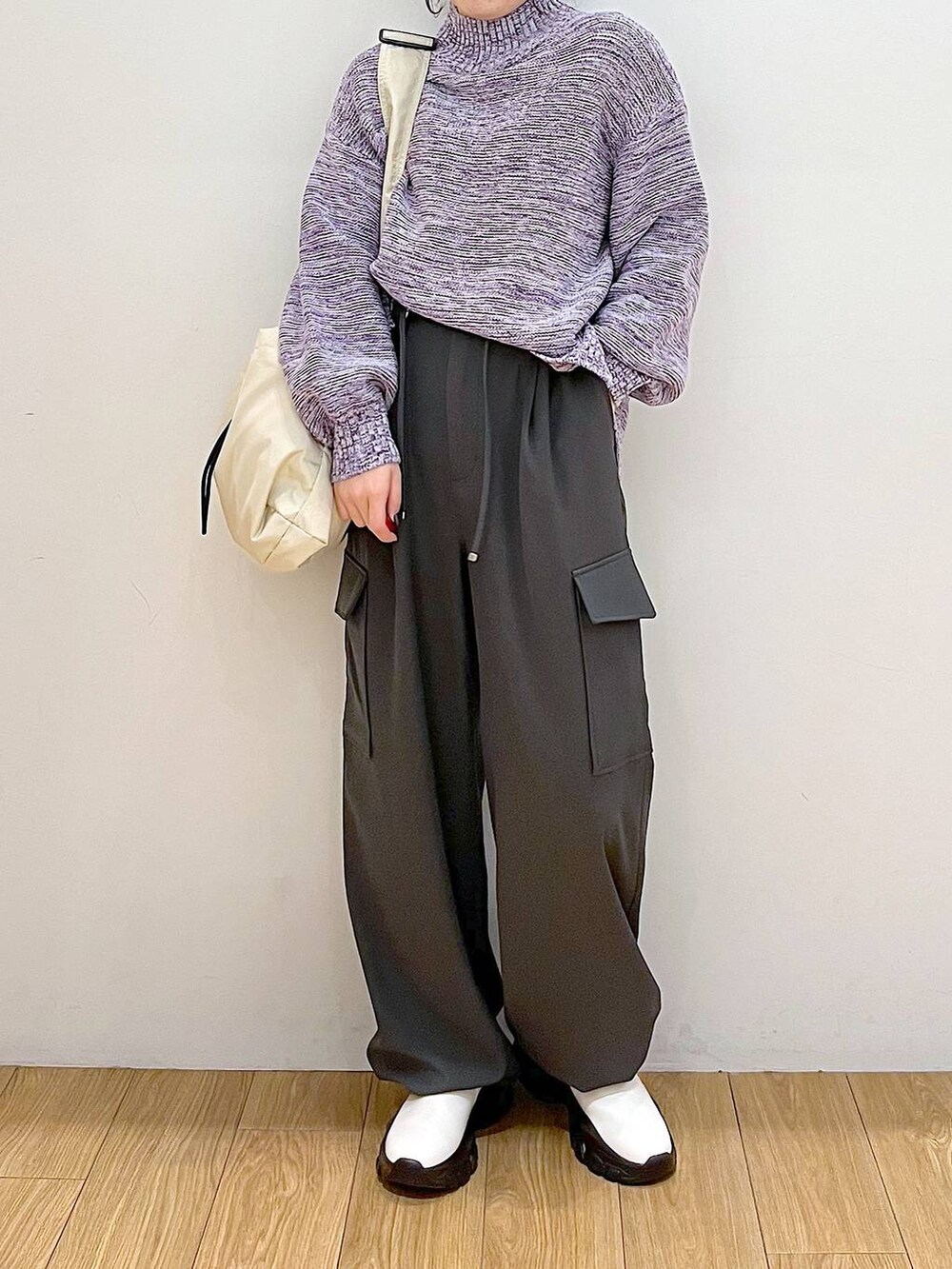 パープル系のニット/セーター、グレー系のカーゴパンツ、ホワイト系のブーツを着用したレディースの冬コーディネートの5枚目の写真