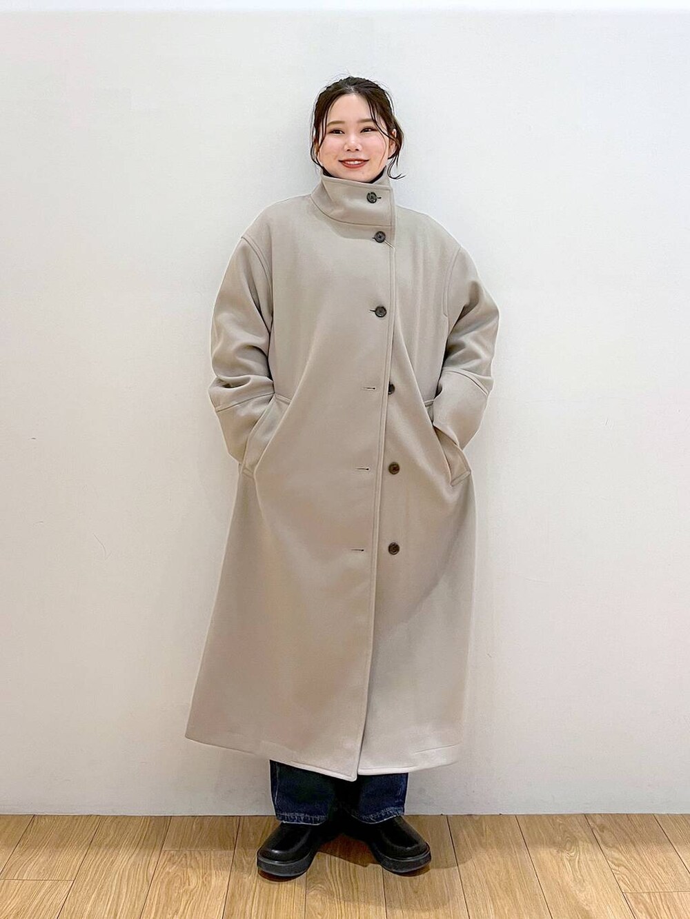 ブラウン系のチェスターコート、ブルー系のデニムパンツ、ブラック系のブーツを着用したレディースの冬コーディネートの3枚目の写真