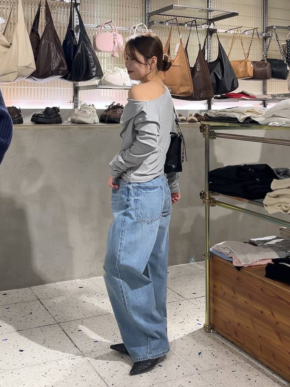 ブルー系のデニムパンツ、ブラック系のショルダーバッグ、ブラック系のパンプスを着用したレディースの冬コーディネートの4枚目の写真