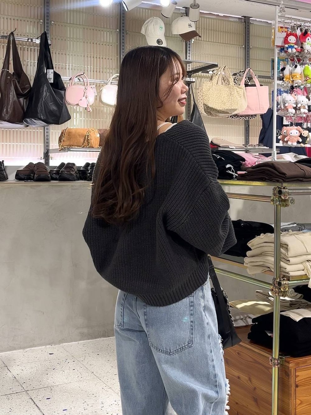 ホワイト系のキャミソール、ブラック系のパンプス、ブルー系のデニムパンツを着用したレディースの冬コーディネートの4枚目の写真