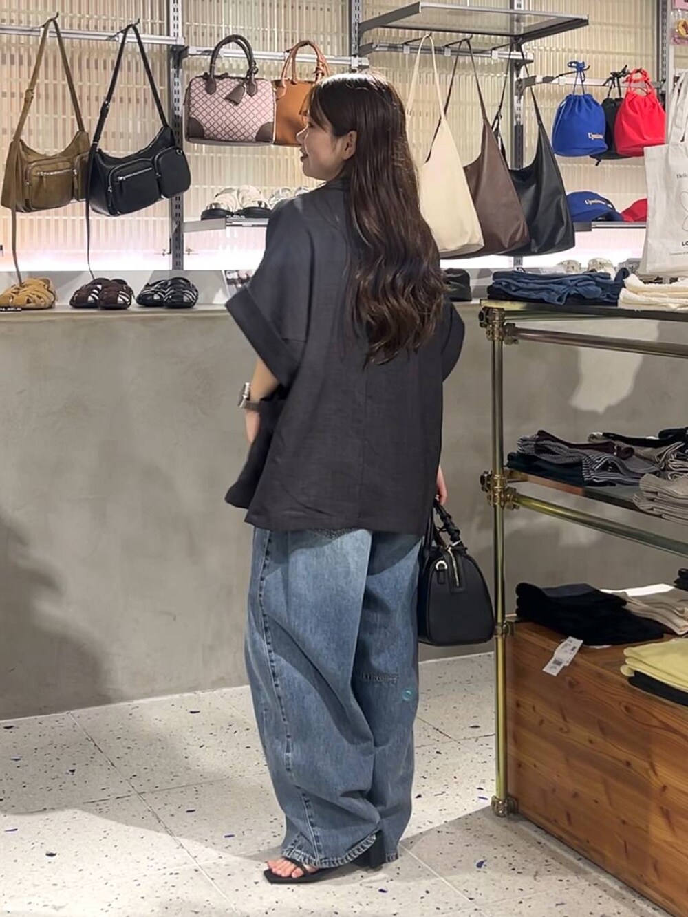 ホワイト系のTシャツ/カットソー、ブルー系のデニムパンツ、ブラック系のサンダルを着用したレディースの夏コーディネートの3枚目の写真