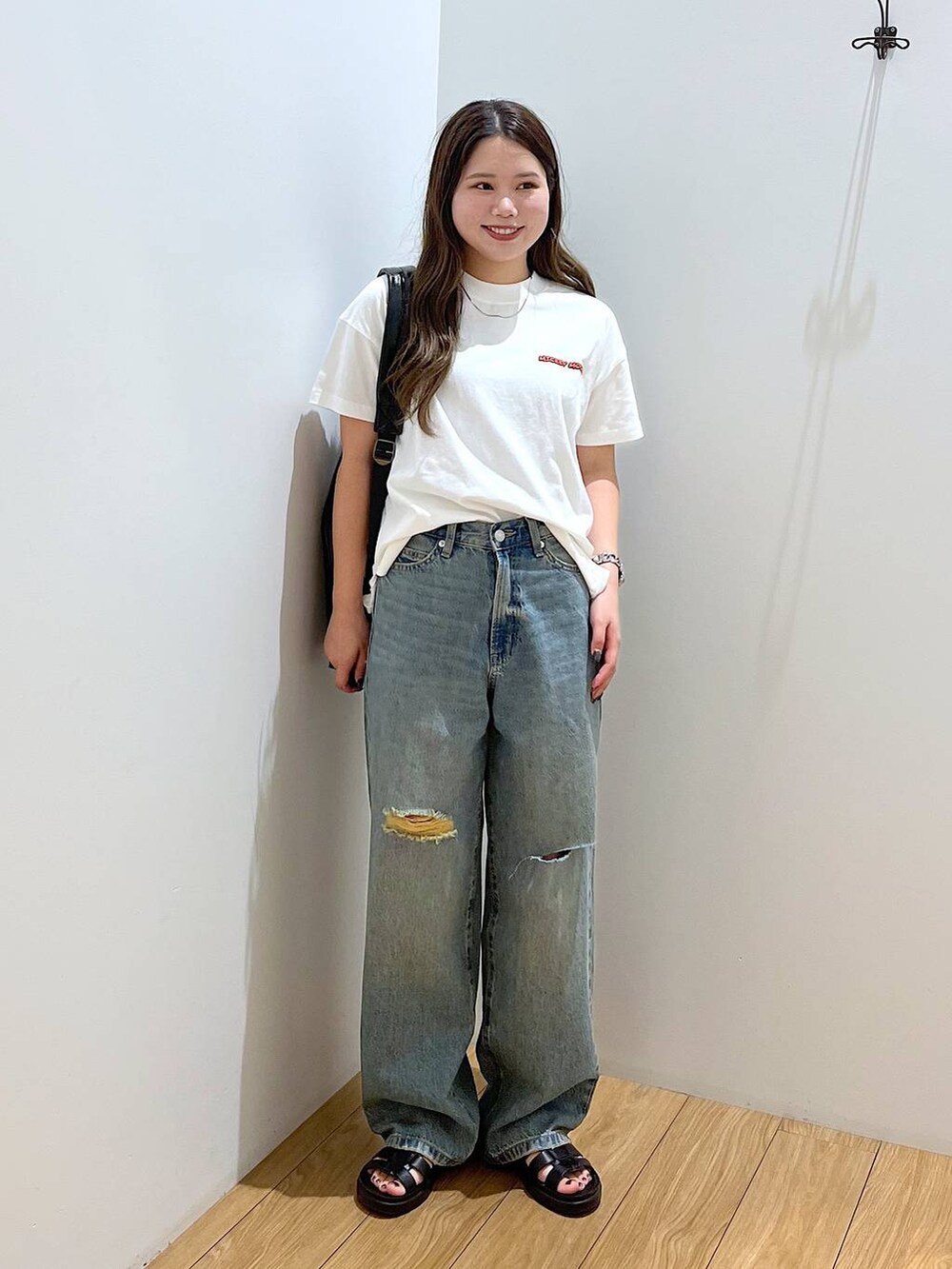 ホワイト系のTシャツ/カットソー、ブラック系のショルダーバッグ、ブラック系のスニーカーを着用したレディースの夏コーディネートの2枚目の写真