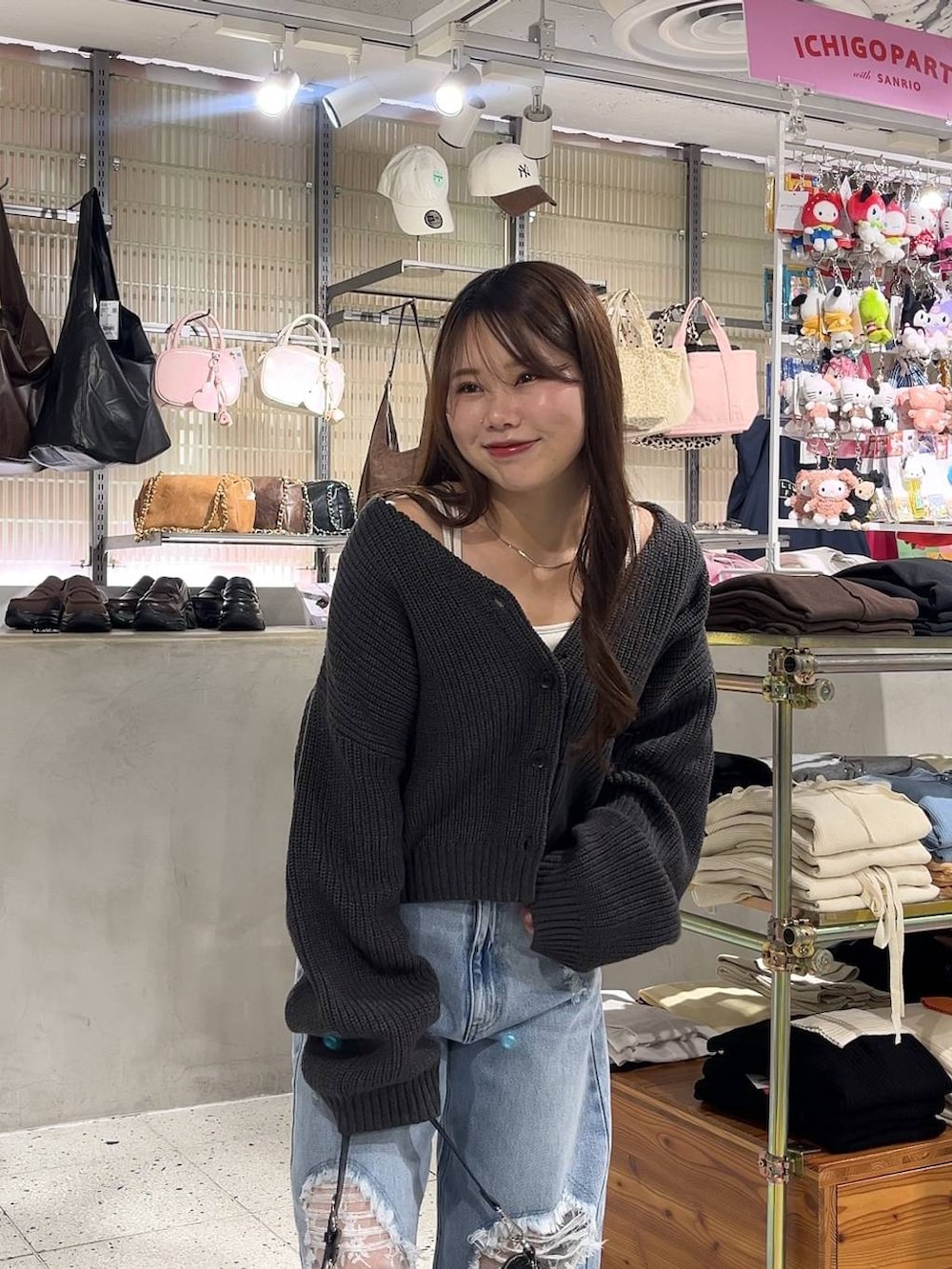 ホワイト系のキャミソール、ブラック系のパンプス、ブルー系のデニムパンツを着用したレディースの冬コーディネートの2枚目の写真