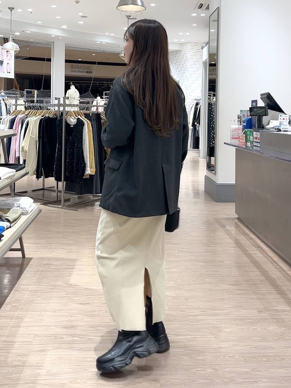 ブラック系のブーツ、ブラック系のショルダーバッグ、グレー系のテーラードジャケットを着用したレディースの冬コーディネートの3枚目の写真