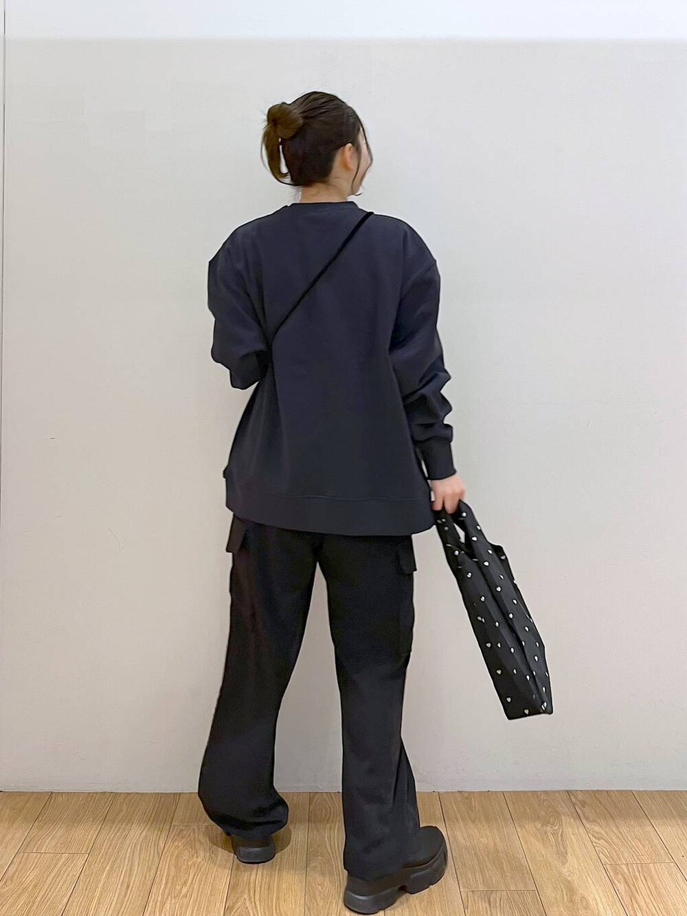 ブラック系のブーツ、ブラック系のハンドバッグ、ブラック系のカーゴパンツを着用したレディースの冬コーディネートの6枚目の写真